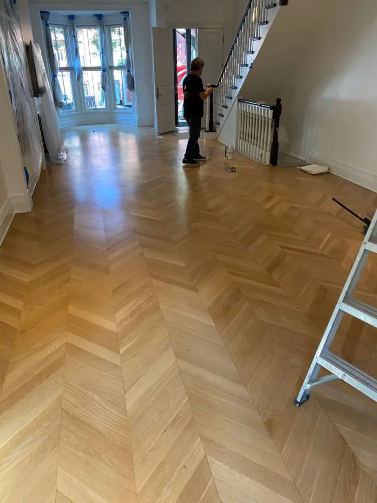 Chevron oak flooring and painted brownstone staircase during final finish work