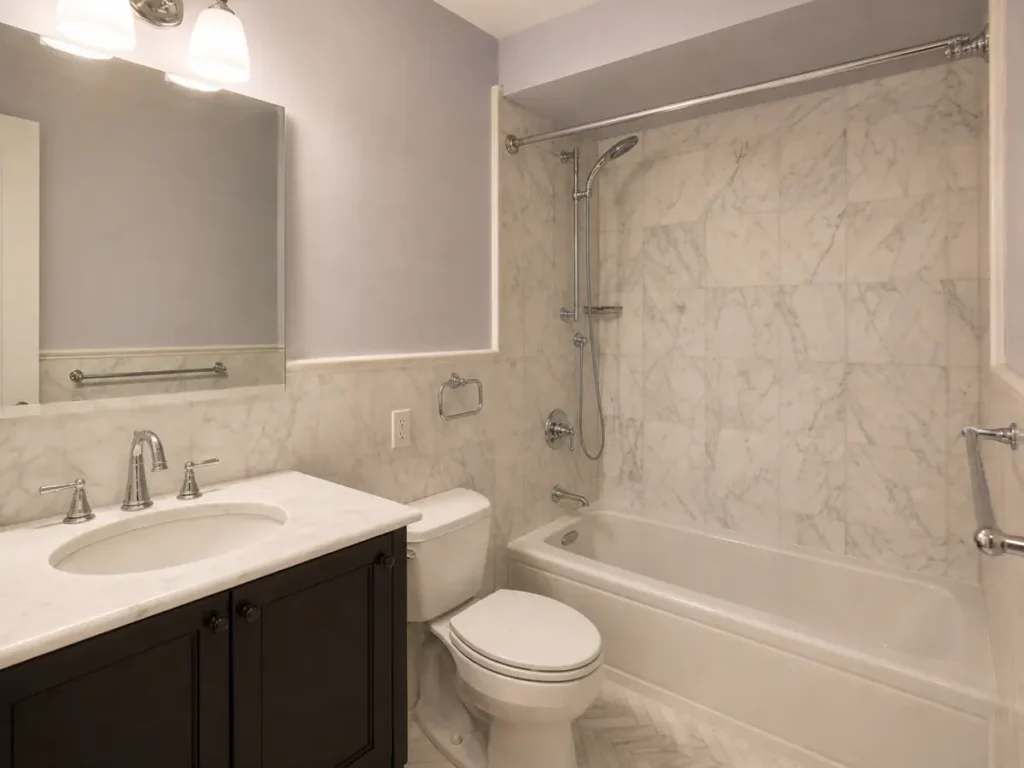 Completed marble tub bathroom with dark vanity, chrome fixtures, and herringbone floor