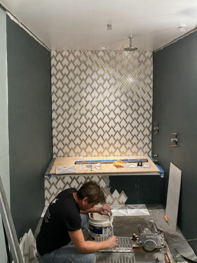 Level view of geometric accent tile being installed during the Long Island City shower rebuild