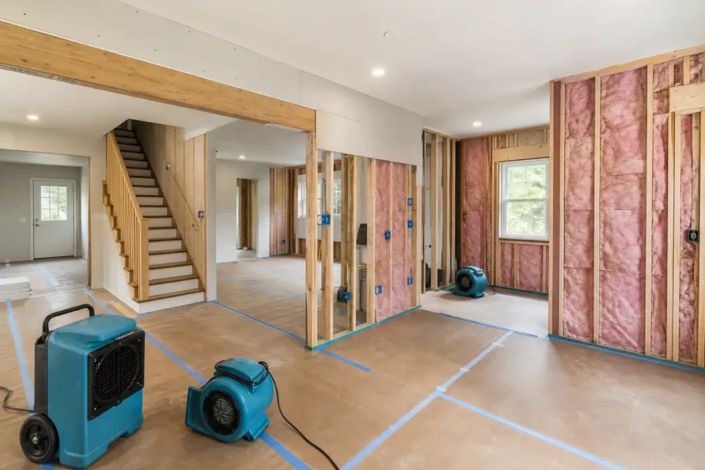 Organized Staten Island residential damage restoration rebuild with new framing, insulation, protected floors, and drying equipment