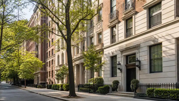 Tree-lined Upper East Side street with limestone and brick pre-war apartment buildings