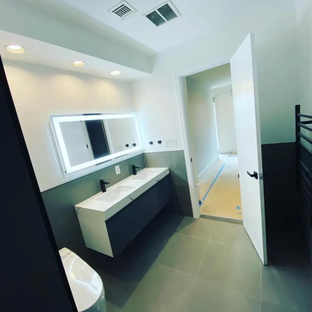 Floating double vanity with illuminated mirror and matte-black faucets in Williamsburg bathroom